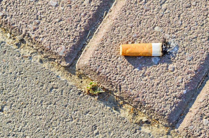 Closeup of a cigarette butt thrown on the pavement